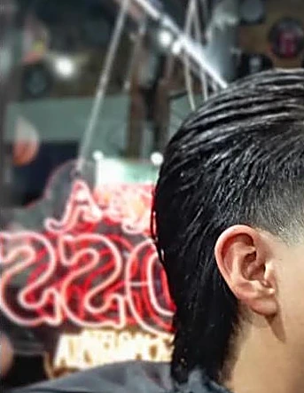 Letrero de neón rojo que dice Like a Boss reflejado detrás de un corte